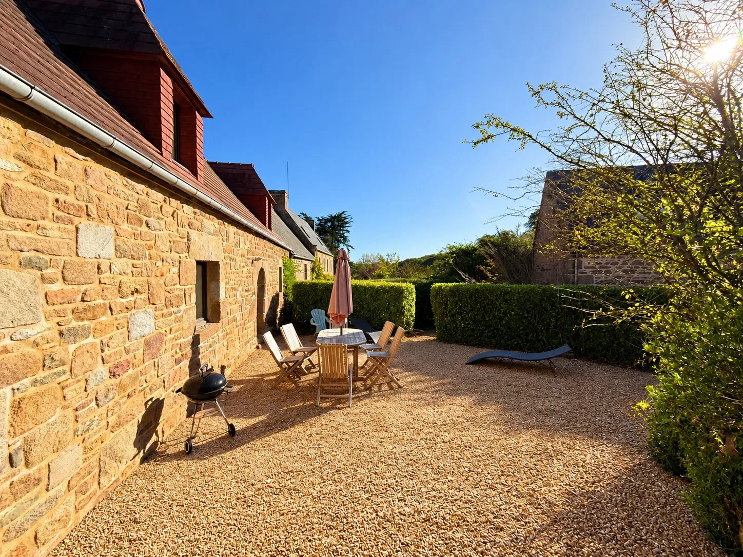 La terrasse de la maison, avec barbecue et salon de jardin